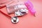 Close up of blister pack, pill box and stethoscope on pink