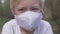 Close-up of a blond boy in a protective medical mask