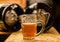 Close up of a blonde craft beer filled into a pint glass on wooden table