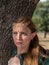 Close-up of blonde girl with blue eyes and elf ears wearing a green cape