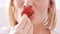 Close up on a blonde woman eating a strawberry