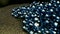 Close up of blue beads garland lying on the carpet. Stock footage. Decorative background with shining beads garland