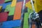 Close-up of a blue climbing knot hanging in front of a colorful gym climbing wall.