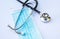 Close-up of blue facemask and stethoscope on white background