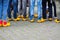 Close up of blue jeans legs of group of people wearing traditional wooden clogs during guided city tour - Xanten, Germany