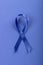 Close-up of blue stomach cancer awareness ribbon isolated against blue background, copy space