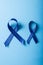 Close-up of blue stomach cancer awareness ribbons isolated on blue background, copy space