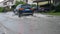 CLOSE UP: Blue SUV drives through the flooded streets of a suburban neighborhood