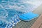 Close up blue swimming foam board put on edge of swimming pool for kids.