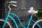 Close-up blue vintage bicycle on which lies bouquet pink peonies