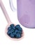 Close-up of blueberries in a wooden spoon. Blueberry products on a white background. Organic berry desserts.