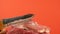 Close-up of a blunt knife trying to cut a piece of raw meat. Sharpening of knives and tools. Selective focus, shallow depth of fie