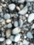 Close up. Blur photo or defocused abstract background of smooth small rocks on black sand. Wallpapers