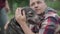 Close-up of blurred man caressing head of domestic dog outdoors. Happy smiling pet owner enjoying morning with pet in