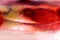 Close-up of blurred strawberries, cherries and kiwi in sweet jelly on pink nougat.