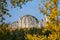 CLOSE UP: Blurry golden branches create a frame for a spectacular mountaintop.