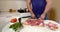 Close-up of the body of a brutal pumped-up man who stands in the kitchen at the table, cutting meat into pieces. Lying