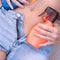 Close Up of the body of a young, tanned girl in denim shorts with sunscreen