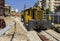 Close up bolted butt of rails and wooden sleepers laid on groundwork crushed stone.