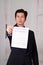 Close up of boss wearing a suit and giving a sheet of paper of termination of contract text on it, in a blurred
