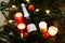 Close up of bottle of champagne with candles and some tangerines in blurred Christmas tree background. Flatlay