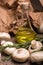 A close-up of a bottle of olive oil surrounded by mushrooms. Vegetable set on a brown paper background.