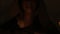 Close-up bottom of the face of the girl magician in a dark room with candlelight smiling from the flash below. Low key