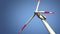 Close-up bottom view of wind turbines in sunny afternoon against blue sky, loop