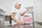 Close up bottom view of young attractive chef woman, adding the flour into pink bowl on electronic weight to make a