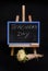 Close-up of a bouquet of asters flowers next to a chalk chalkboard with lettering Teachers Day, standing on a wooden table easel,