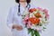 Close-up of bouquet of flowers in hands of female doctor