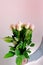 Close-up of bouquet of white, pink roses in hands of young man, brought flowers on date with girlfriend, gives to mom, concept of