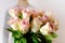 Close-up of bouquet of white, pink roses in hands of young man, brought flowers on date with girlfriend, gives to mom, concept of