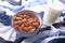 Close up of a bowl of almond nuts and milk on table cloth