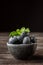 Close up of bowl with blueberries soaked with mint leaves, black background,