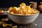 close-up of bowl of crispy, golden chips with salt and pepper