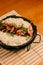 Close-up of a bowl of steaming white rice and meat