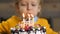 Close-up of boy blowing candles on birthday cake