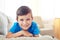 Close-up of boy with cornflower blue eyes lying on sofa