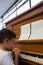 Close up of boy eating apple while sitting by piano