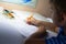 Close-up of boy hand with pencil writing English words. The boy writes his first test on English. Child writing