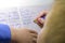 Close-up of boy hand with pencil writing english words by hand on traditional white notepad paper.