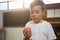 Close up of boy holding apple while standing against piano