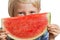 Close-up of boy peeking over water melon