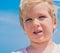 Close-up boy portrait . Serious male child squints a little in sunny weather looks into the distance. Clear blue sky