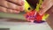 Close-up of a boy`s hand create a plastic flower. He uses a 3D pen.