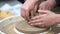 Close-up of the boy's hands sculpting clay dishes on a potter's wheel. pottery training