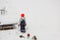 Close-up of boy standing and gazing at snow-covered mountain in garden on frosty winter day.