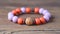 a close up of a bracelet on a wooden surface with beads and beads on it, and a beaded bracelet with a wooden bead