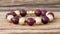 a close up of a bracelet on a wooden surface with beads and beads on the end of the bracelet, and a bead of gold and burgundy